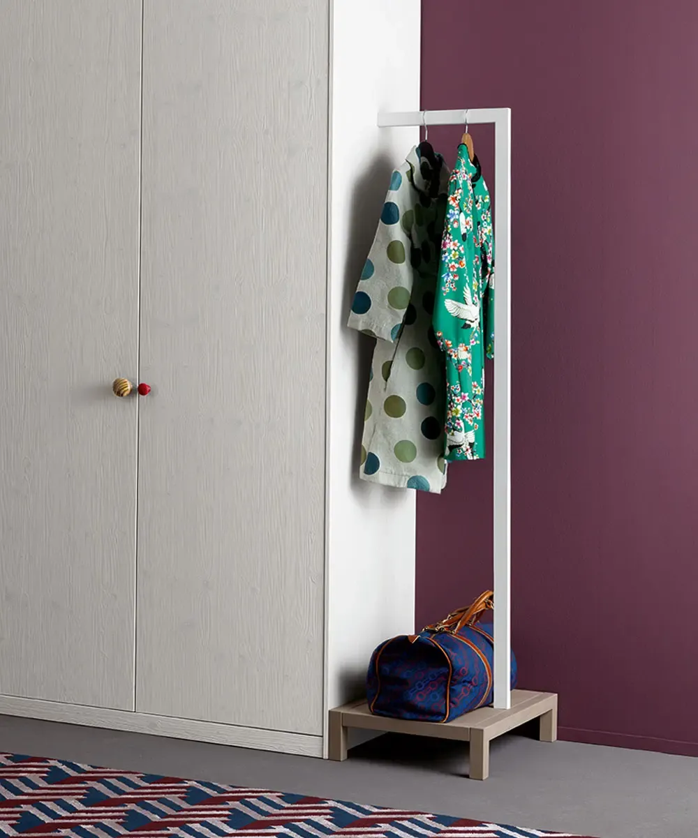 Armadio Easy Callesella con pomelli colorati accanto a un appendiabiti a stelo
