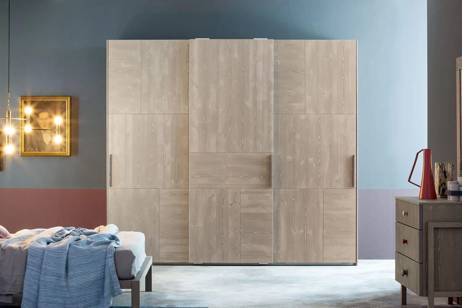 Armadio Tetris Callesella a tre ante in un’unica finitura chiara accanto al letto