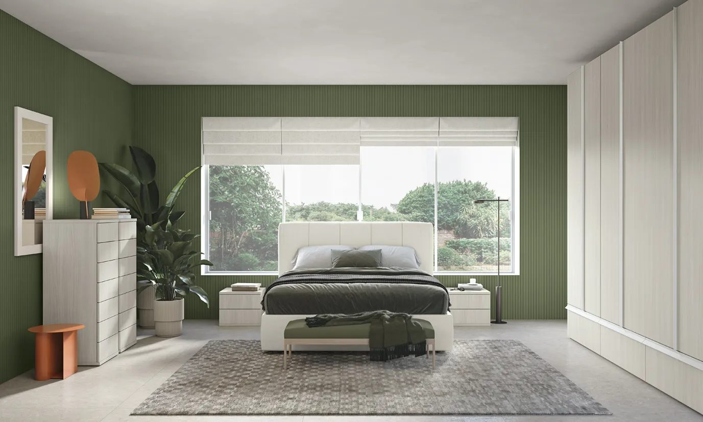 Camera da letto Volo Colombini con parete verde, letto imbottito chiaro e armadio a tutta altezza