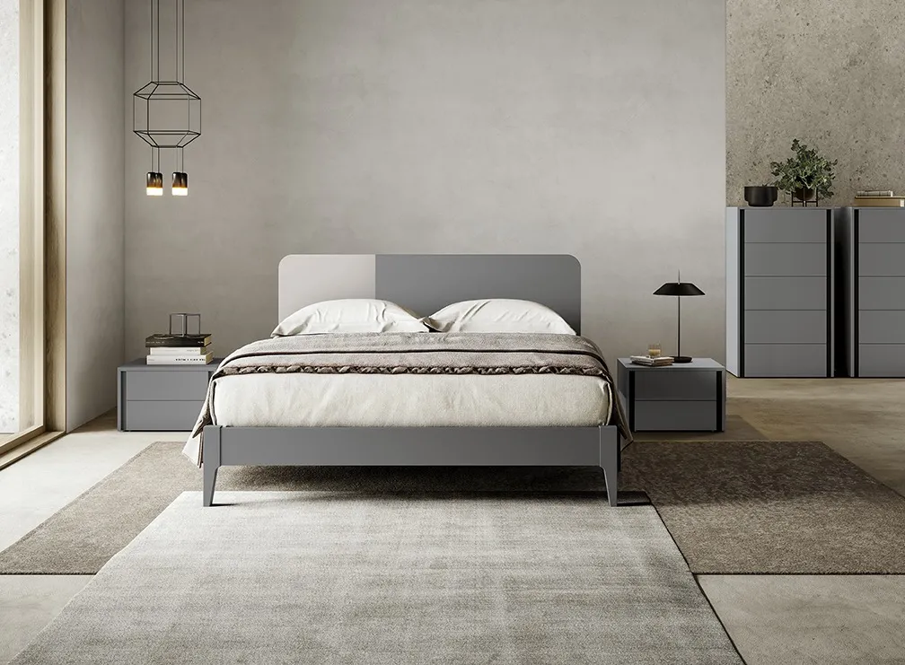 Letto con testata Sector Colombini grigio a due toni tra comodini a cassetti e settimino