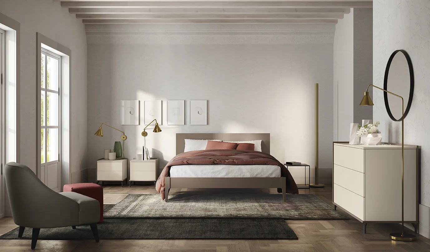 Letto con testata Mushy Colombini color tortora su gambe affusolate in una camera con travi a vista
