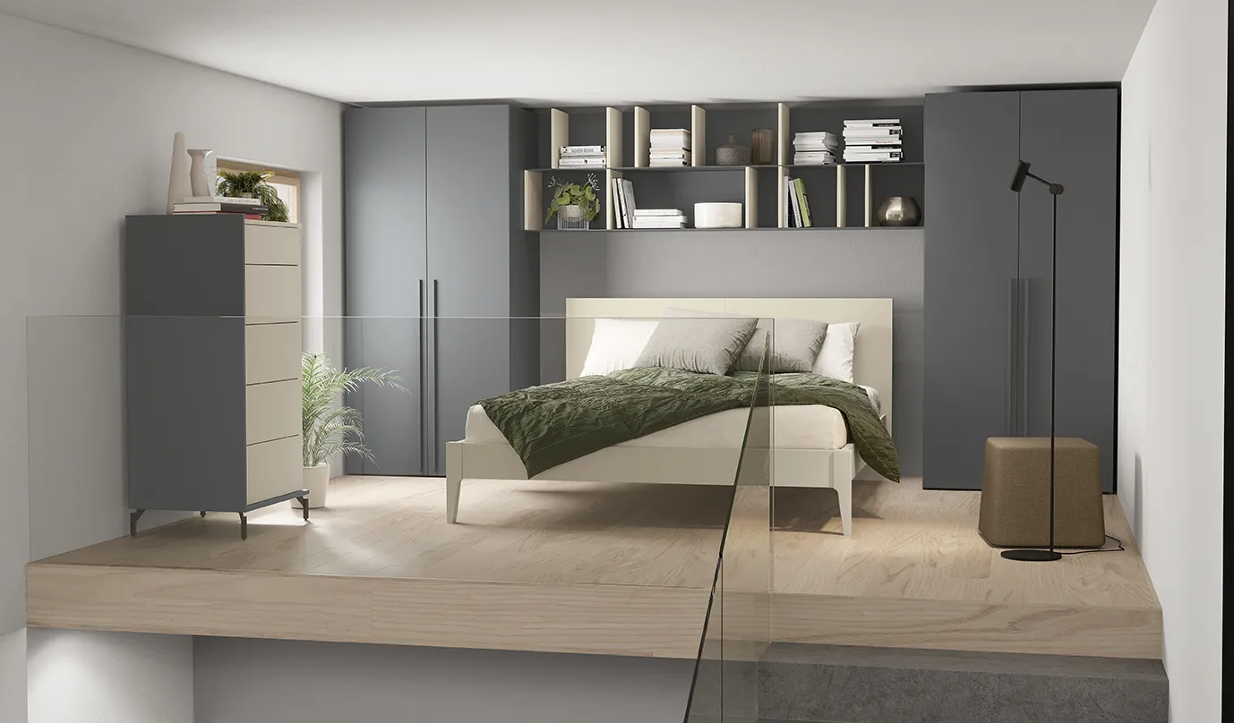 Letto Mushy Colombini color crema su soppalco davanti a un armadio a ponte grigio con vani a giorno