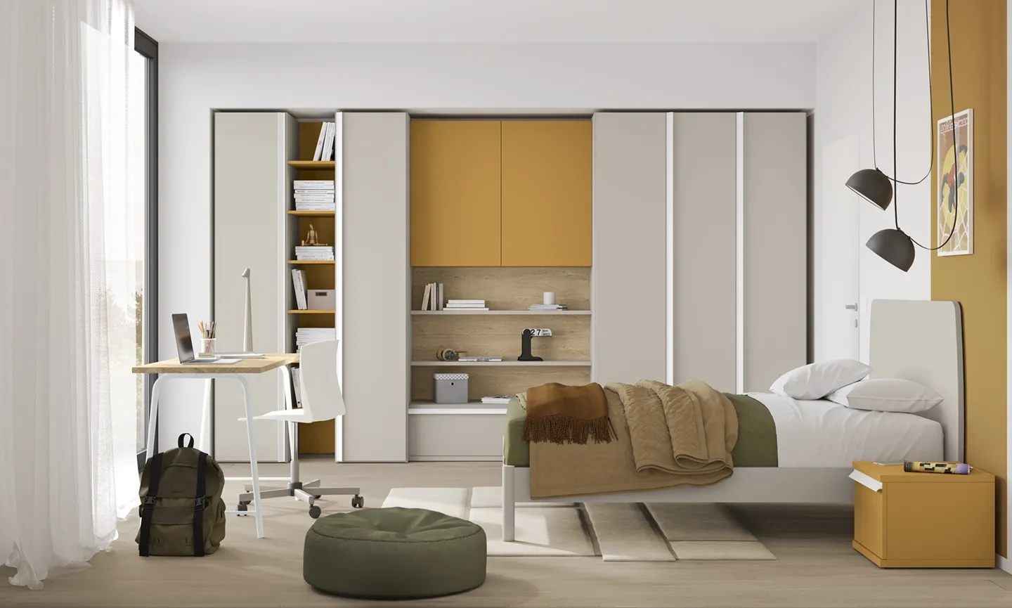 Letto singolo Soy Colombini con testata sabbia davanti ad armadi con vano libreria e pensili senape