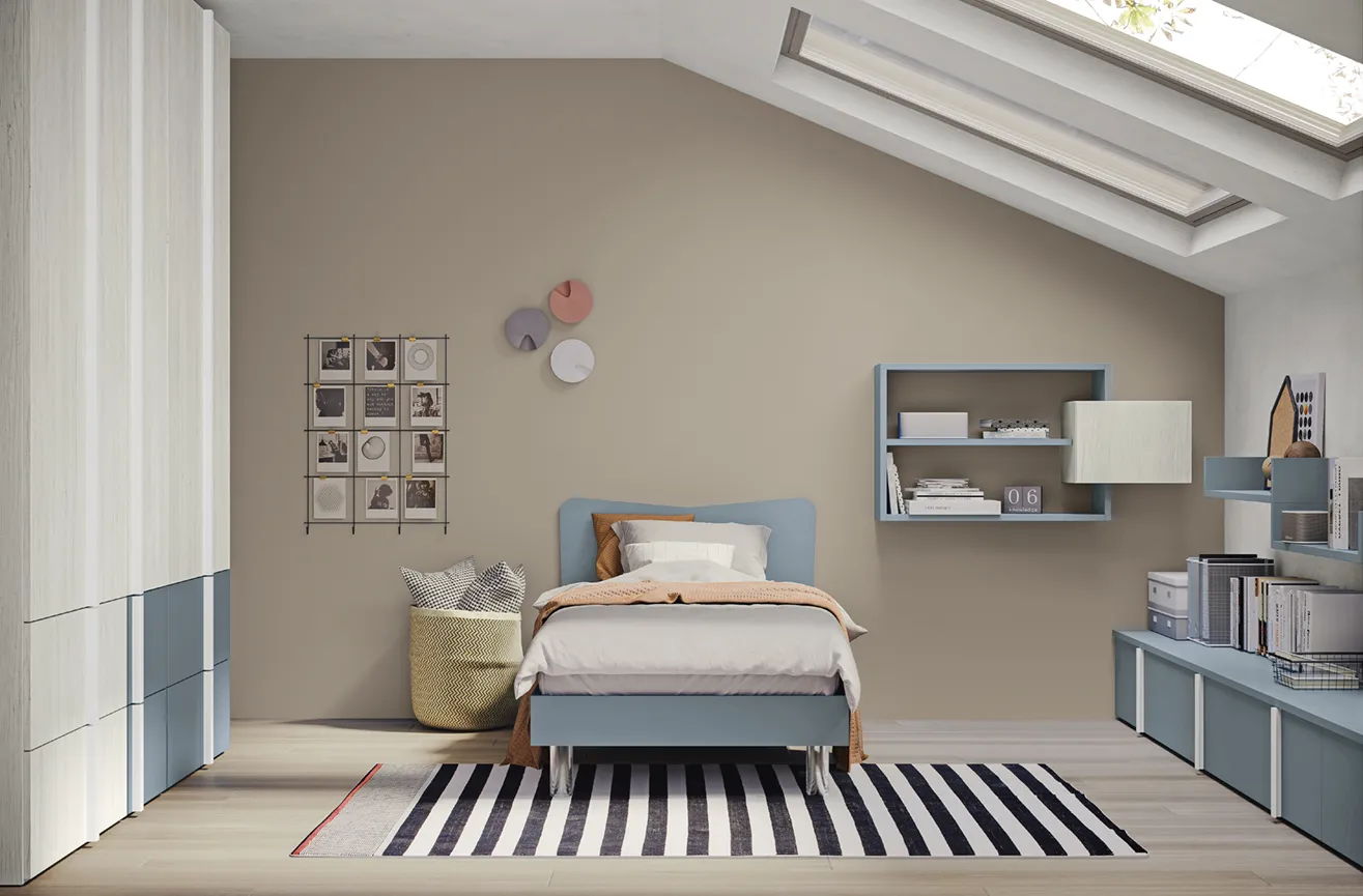 Letto singolo Winner Colombini azzurro con testata ondulata in una cameretta mansardata