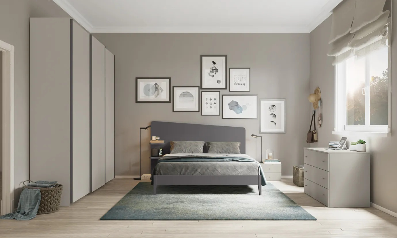Letto con testata Edge Plus Colombini antracite con mensola laterale sotto una parete di quadri