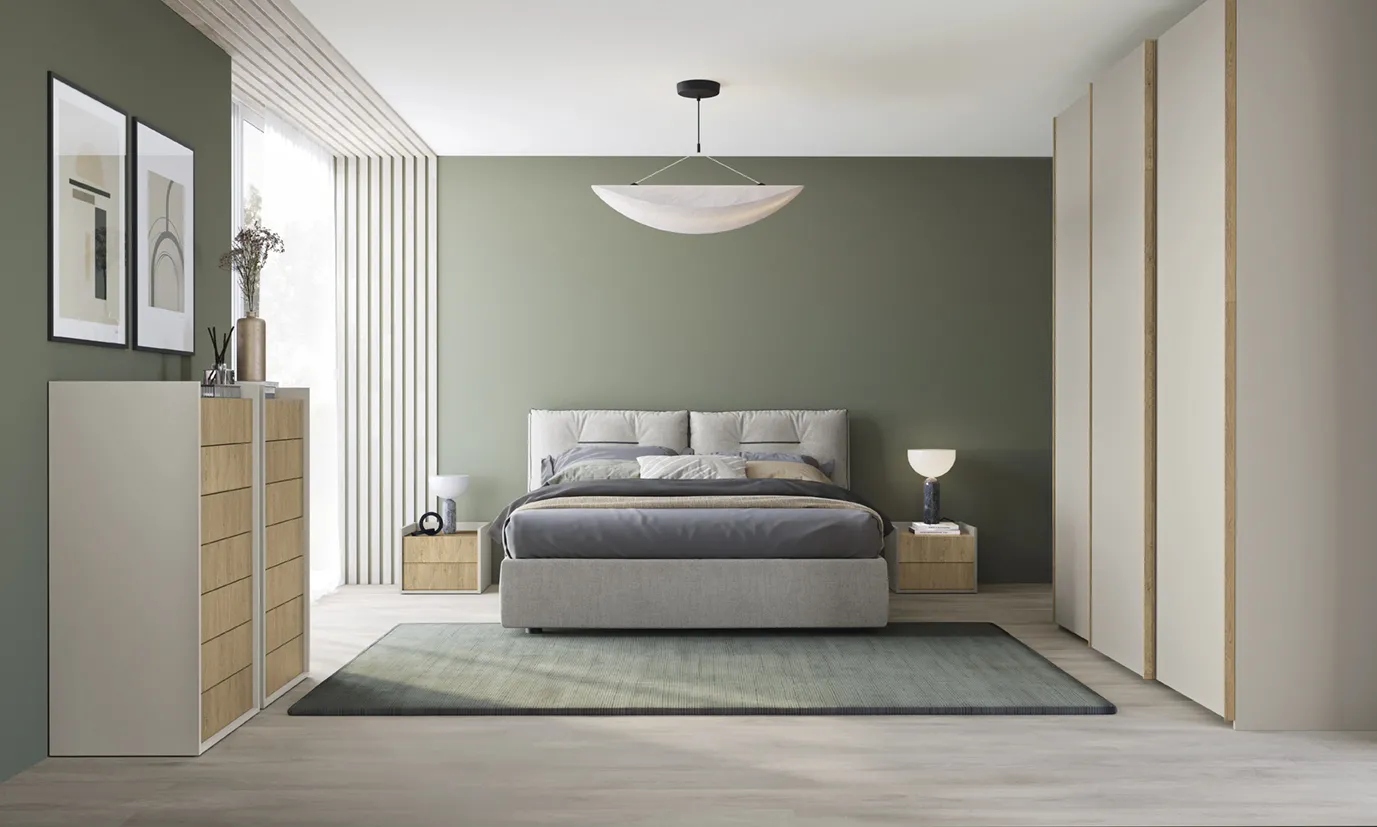 Letto Kiss Colombini grigio chiaro davanti a una parete verde salvia con settimino chiaro
