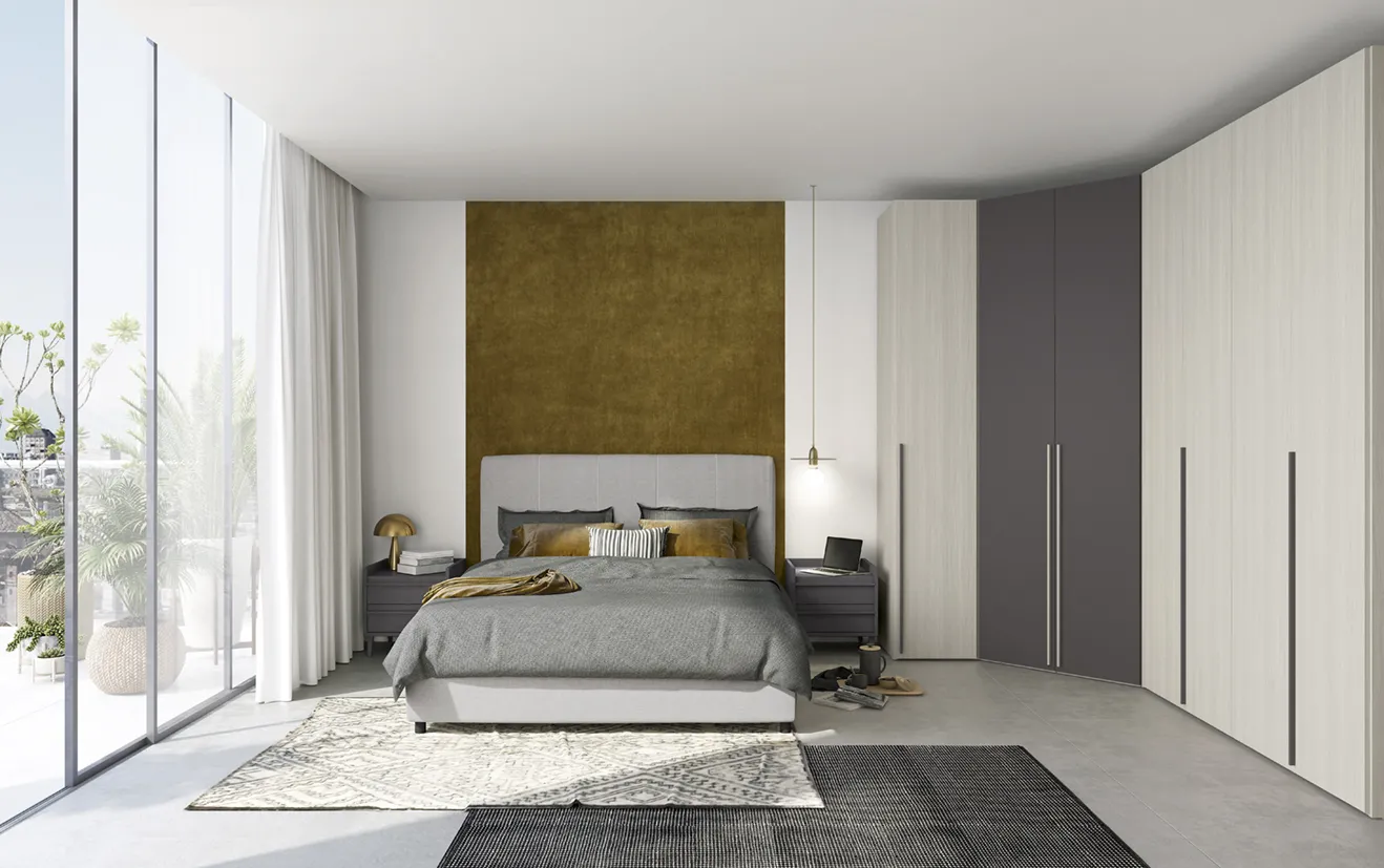 Letto imbottito Rapsody Colombini grigio perla davanti a un pannello color oro