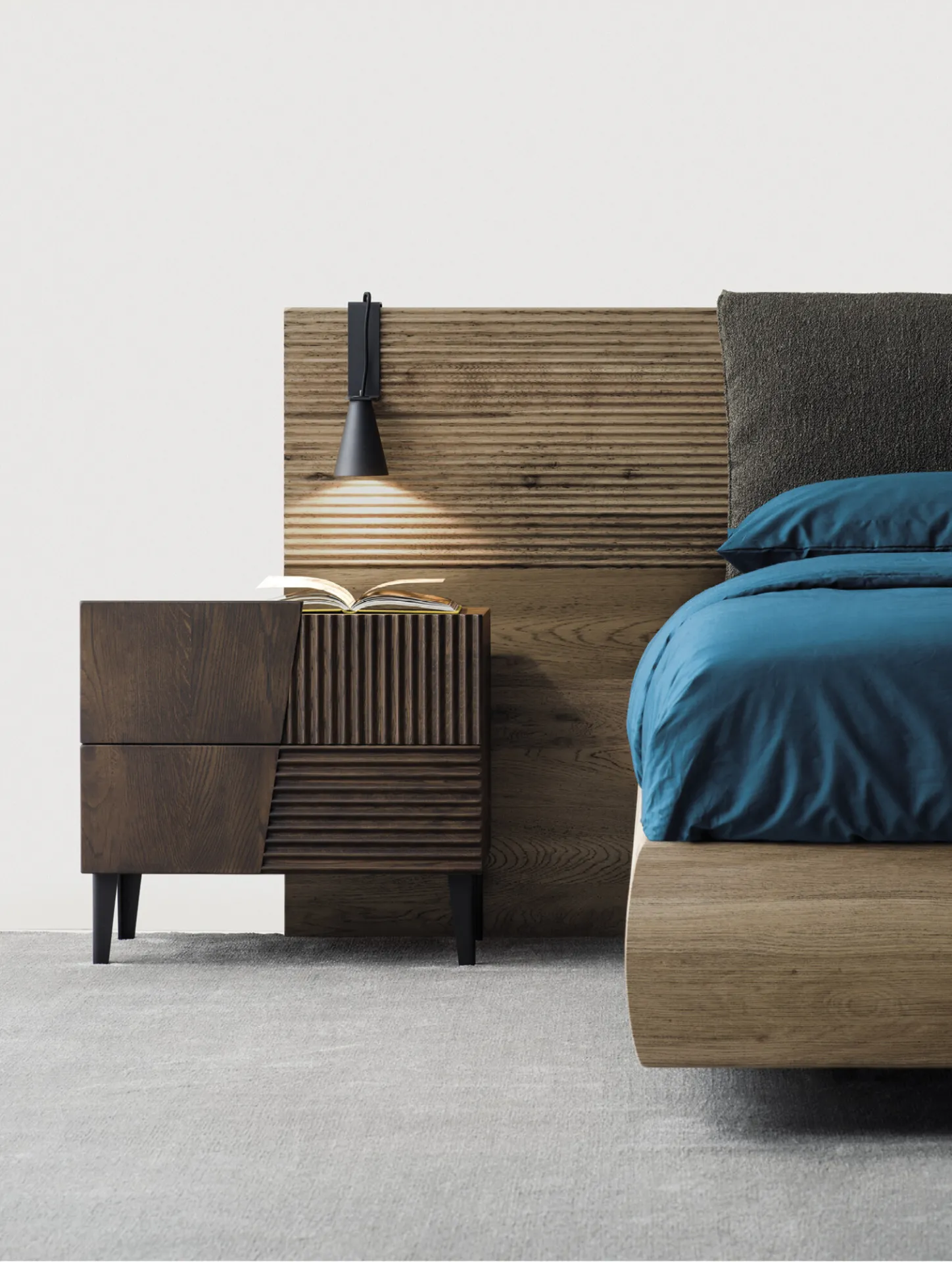 Comodino Design Devina Nais a due cassetti in rovere scuro accanto a un letto con testiera in legno