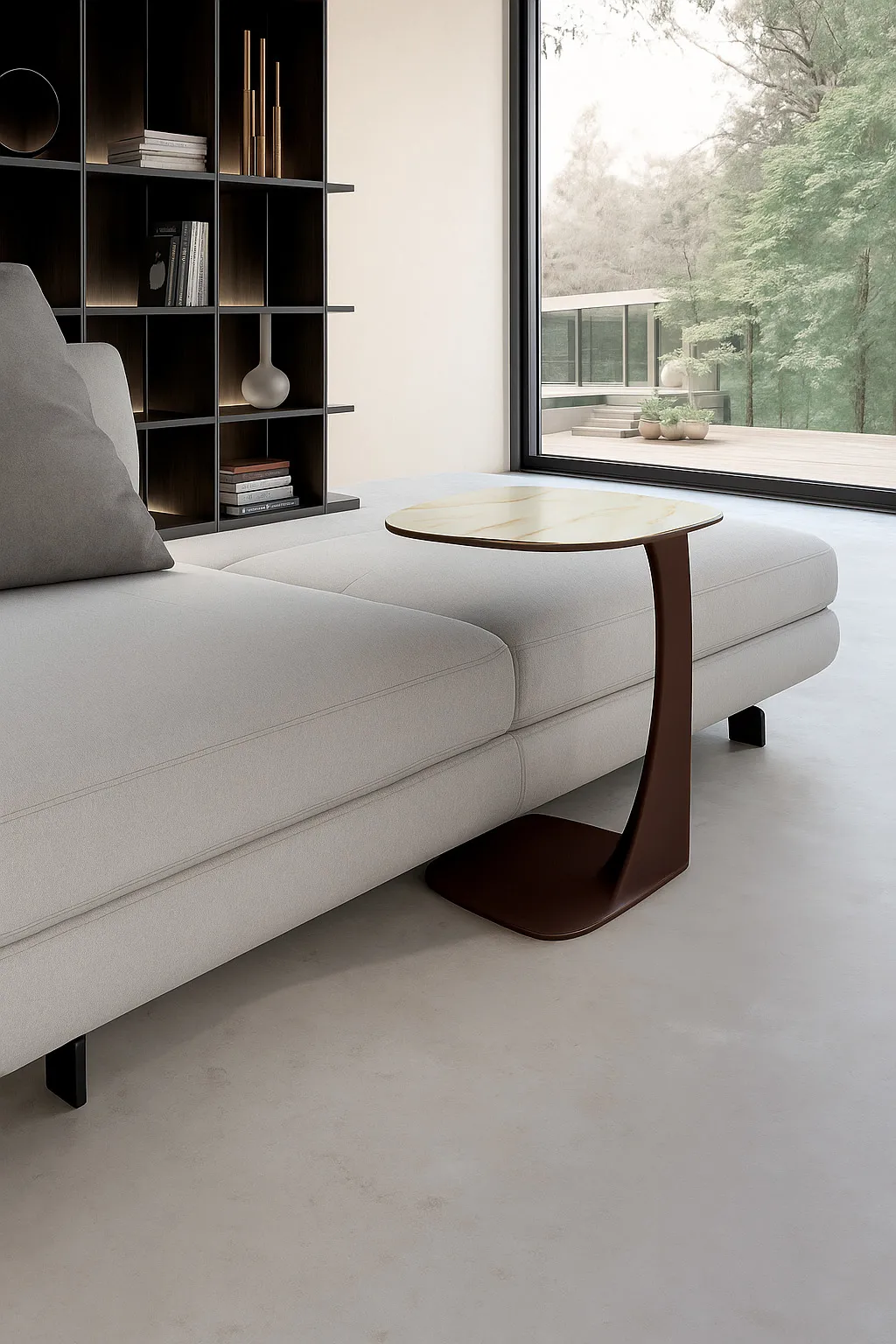 Tavolino Menhir Stones Calacatta oro con stelo bronzo accanto a un divano bianco