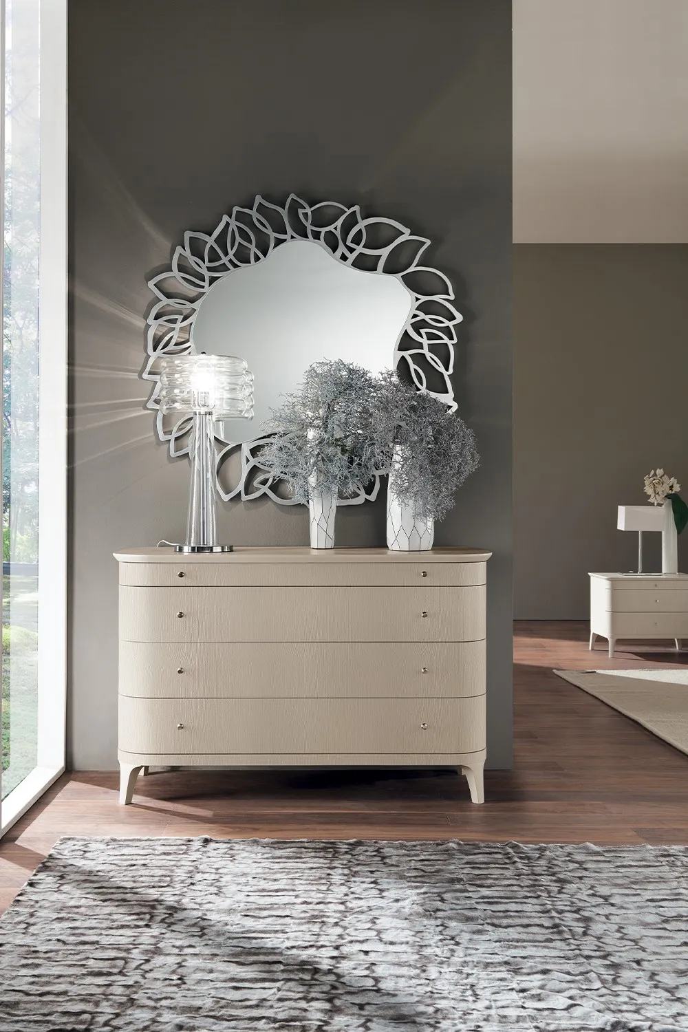 Comò Rosa Charme Le Fablier sotto uno specchio decorativo in camera da letto