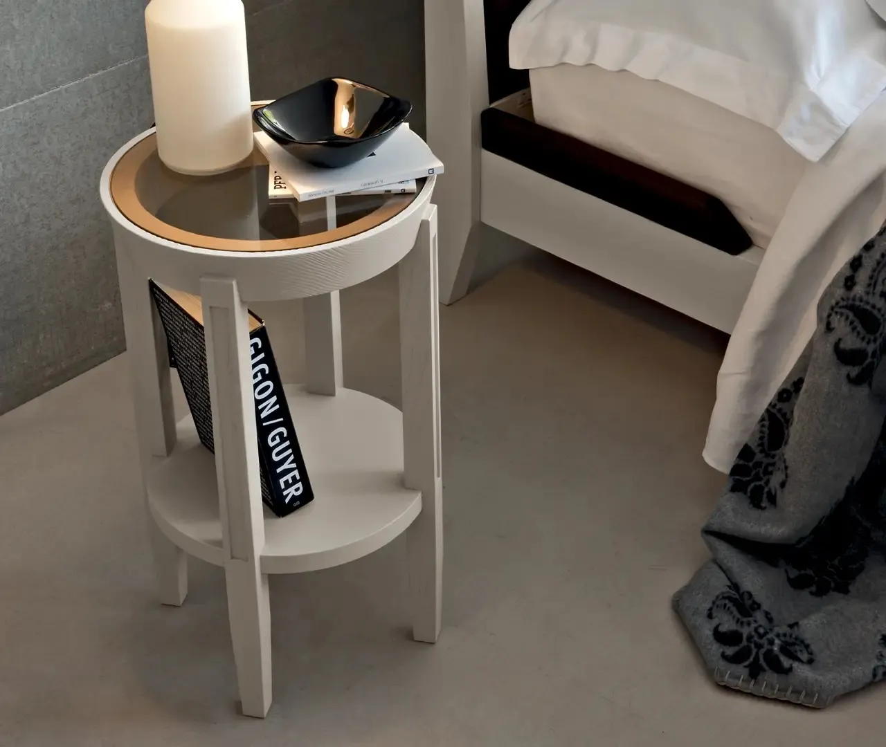 Comodino rotondo Giglio Le Fablier laccato chiaro accanto al letto