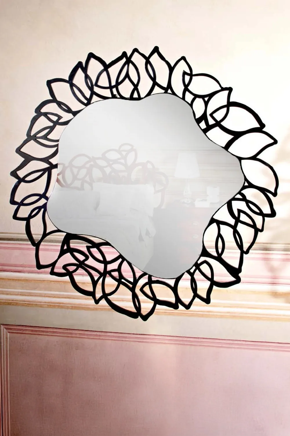 Specchiera Pavè Le Fablier con cornice a petali nera su una parete rosa