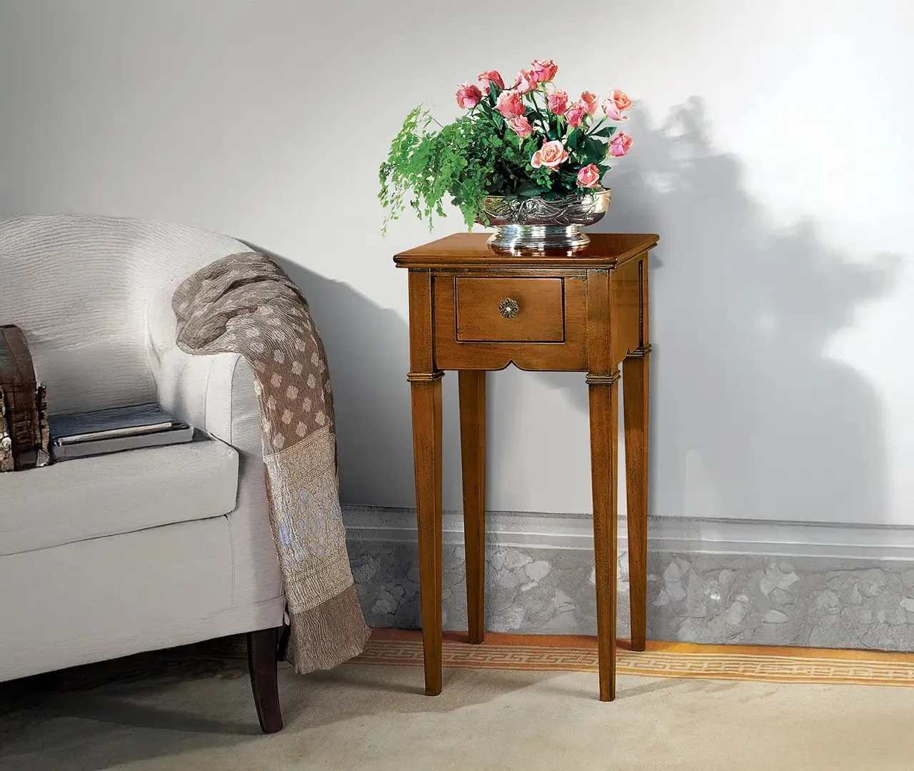 Comodino alto Opale Le Fablier in legno con un vaso di fiori accanto a un divano