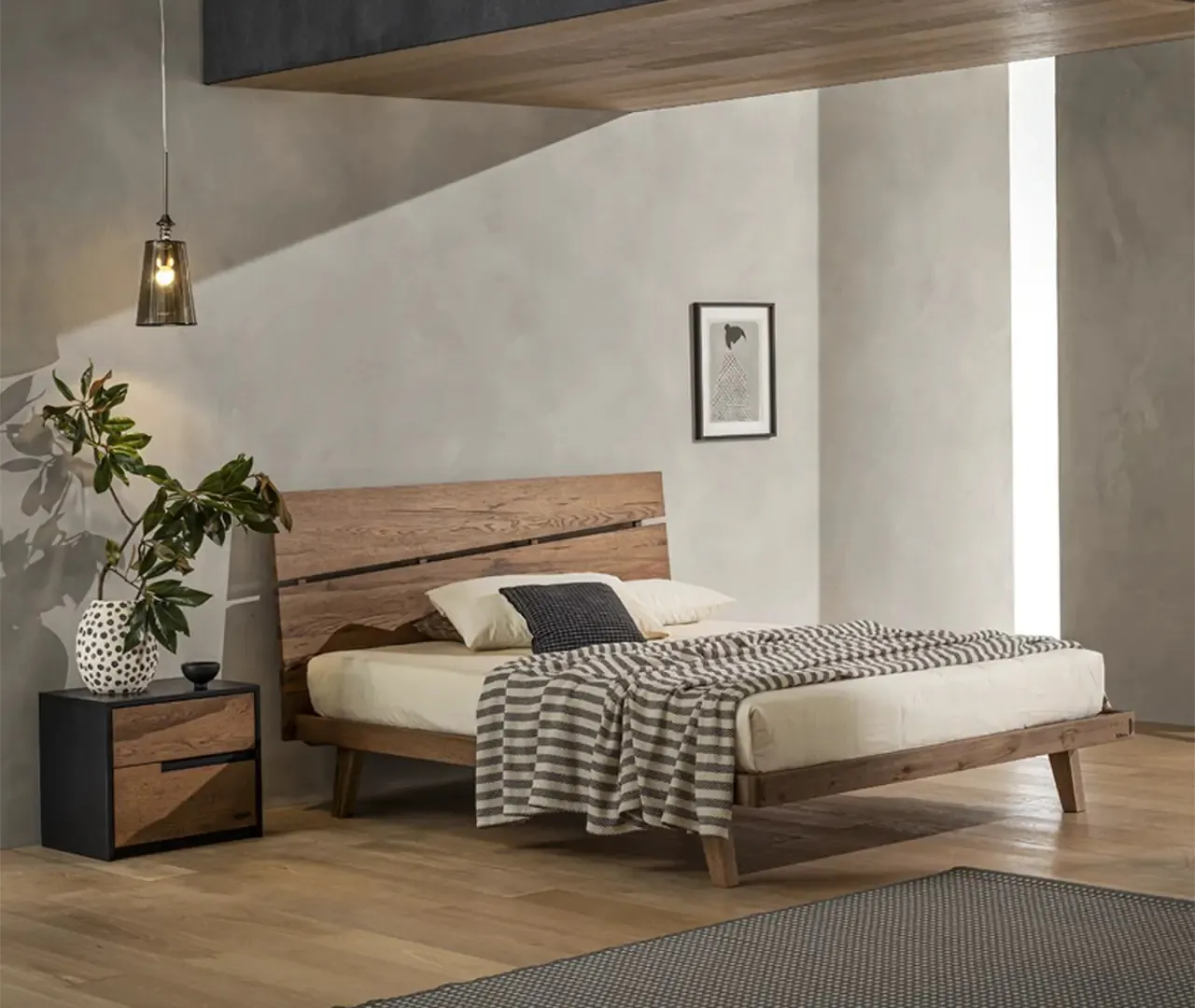 Letto Bogotà Le Fablier in rovere invecchiato scuro con fessura sulla testiera in una camera grigia
