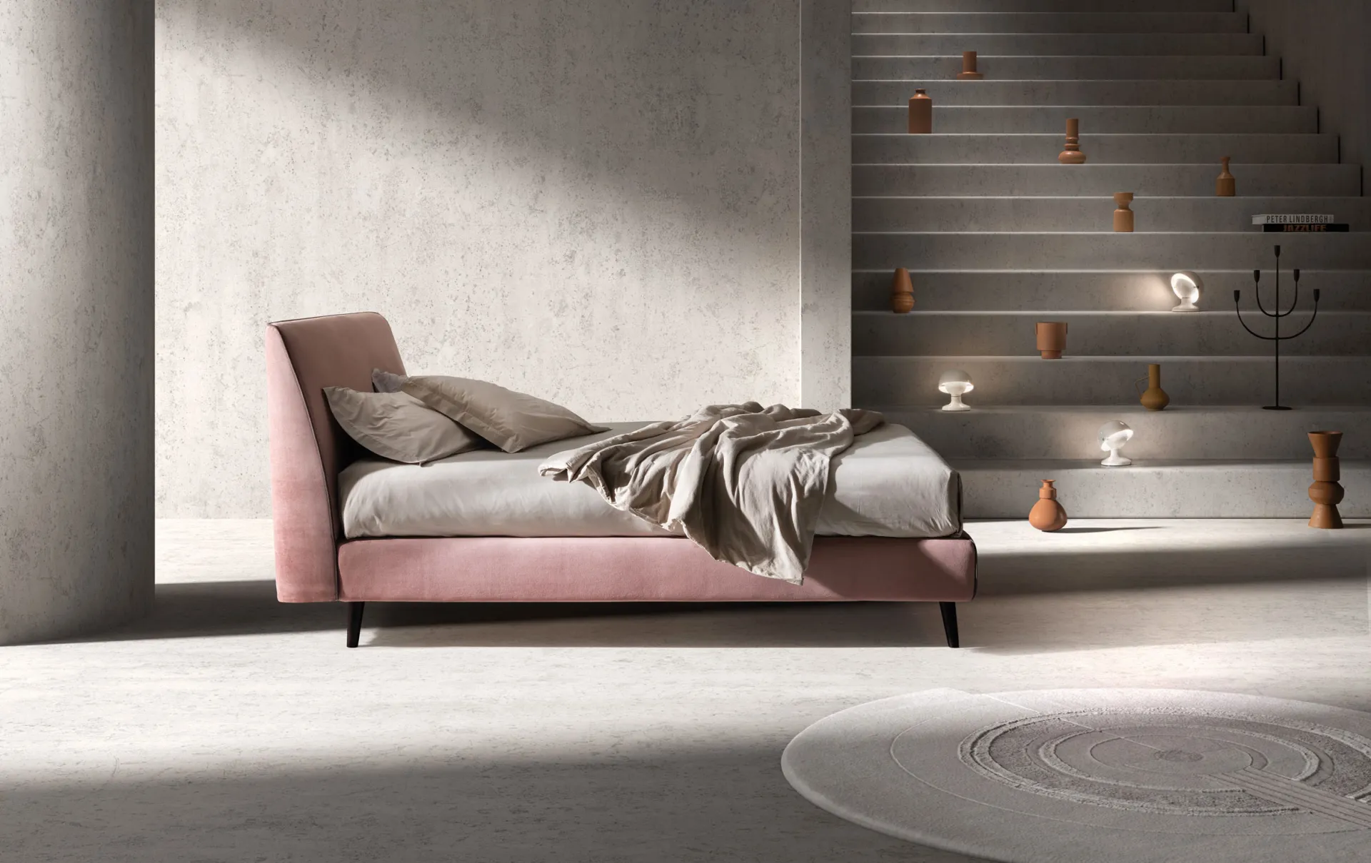 Letto imbottito Time Samoa in velluto rosa antico con testiera inclinata, accanto a una scala