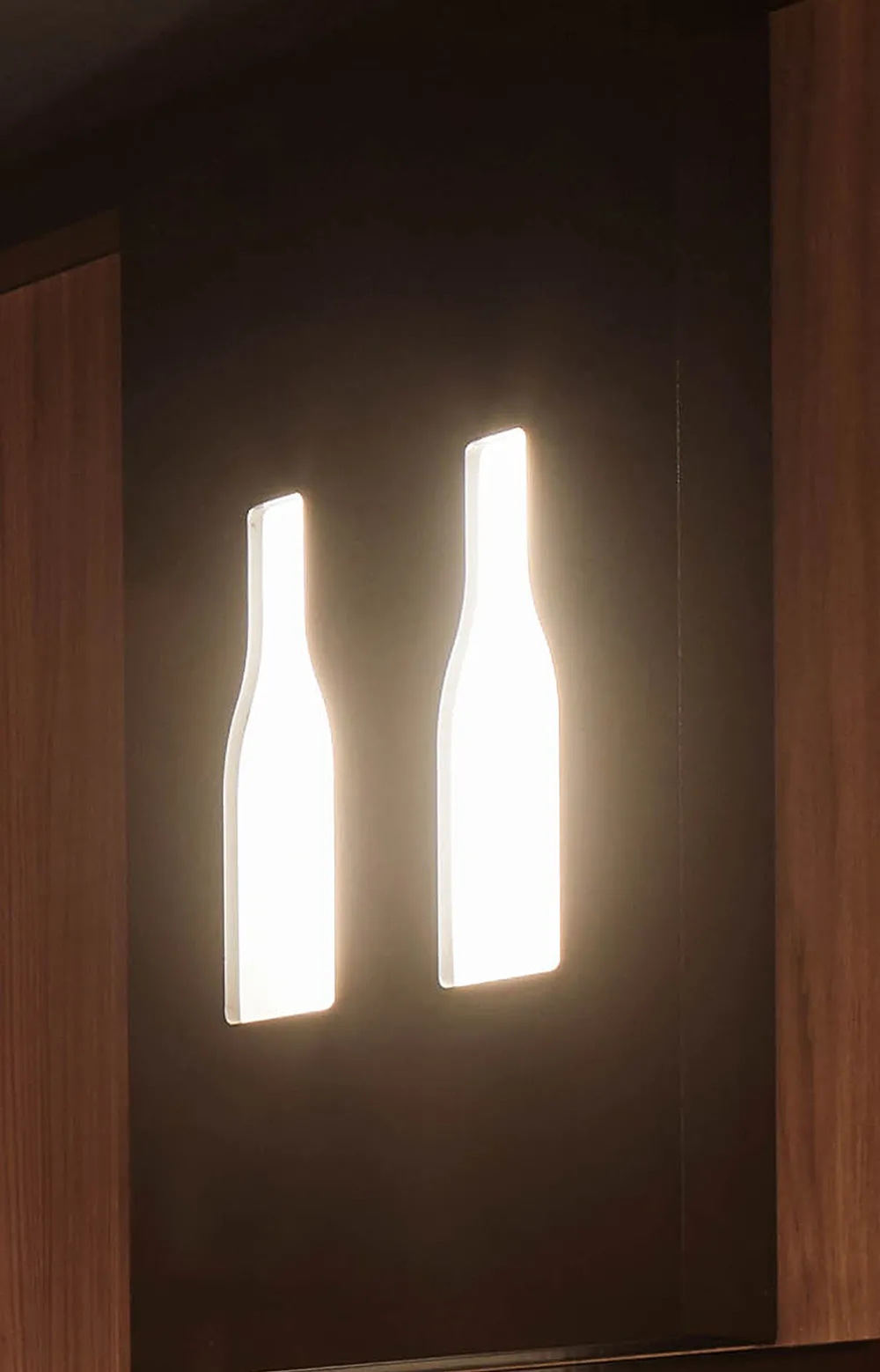 Lampada da parete Tosato 70.07 con due sagome di bottiglia illuminate su pannello in legno scuro