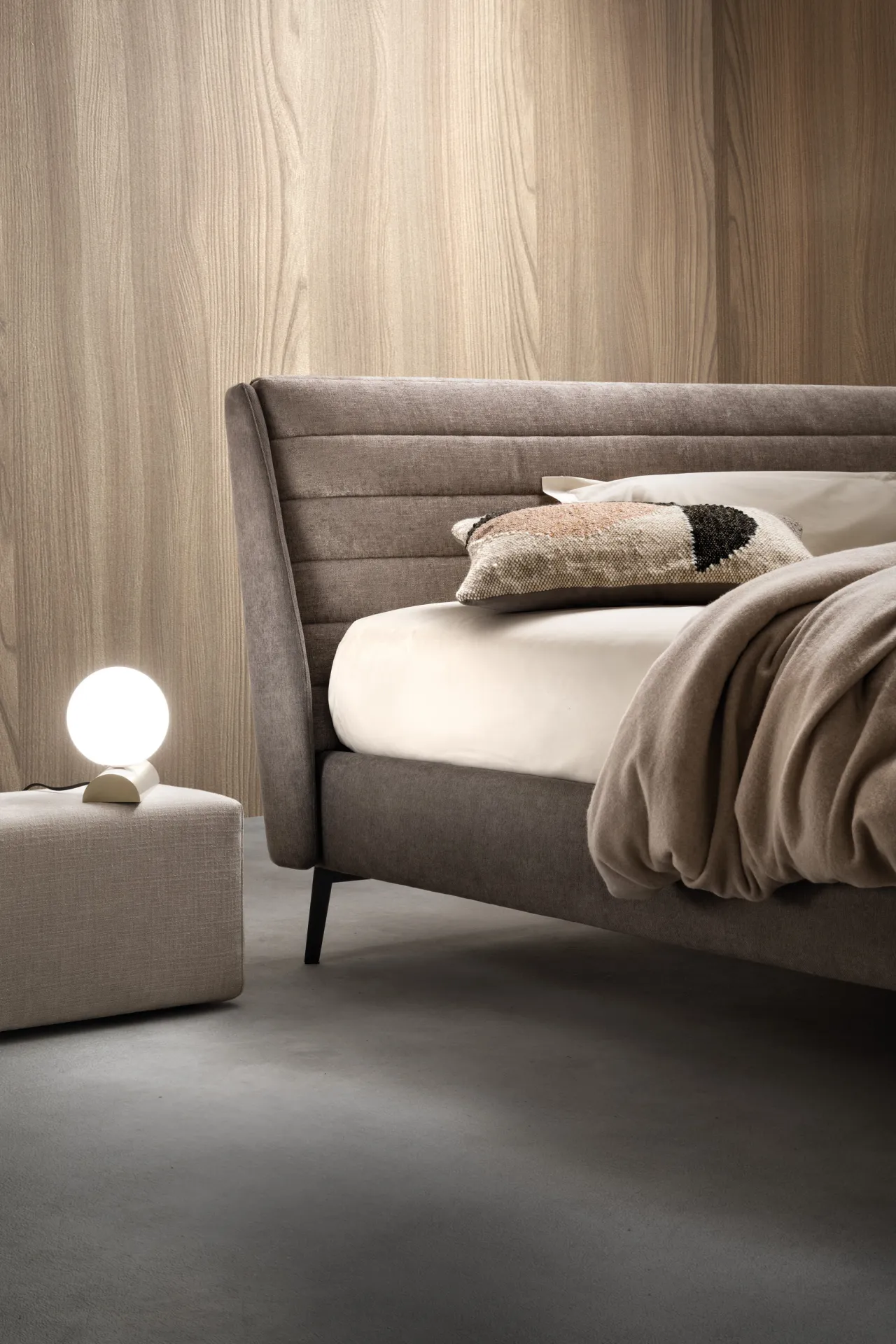 Letto Stick Samoa di tre quarti con testiera a fasce cucite e lampada a sfera sul pouf
