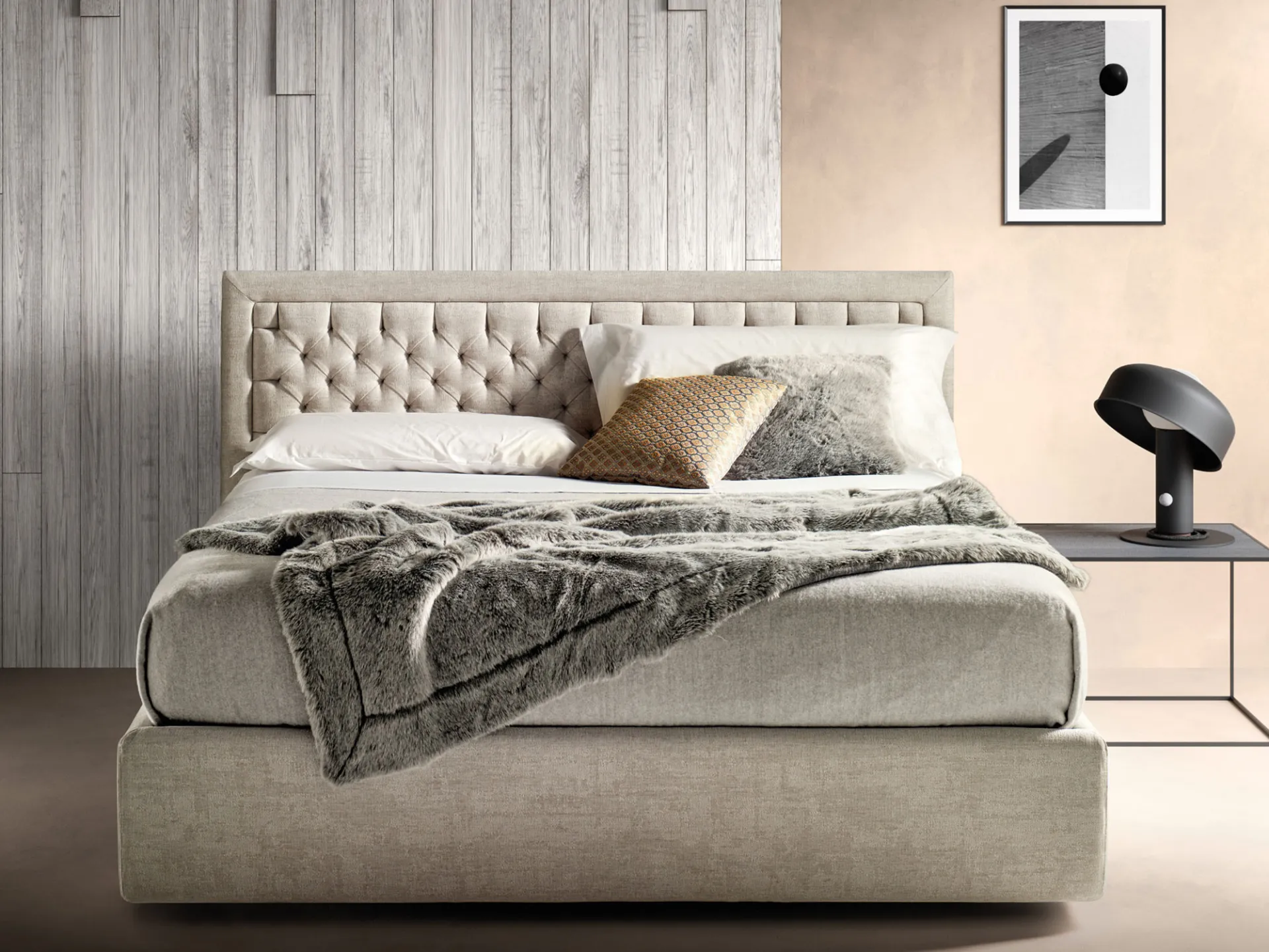 Letto imbottito Nest Samoa beige con pannello capitonné nella cornice, accanto a un comodino in metallo