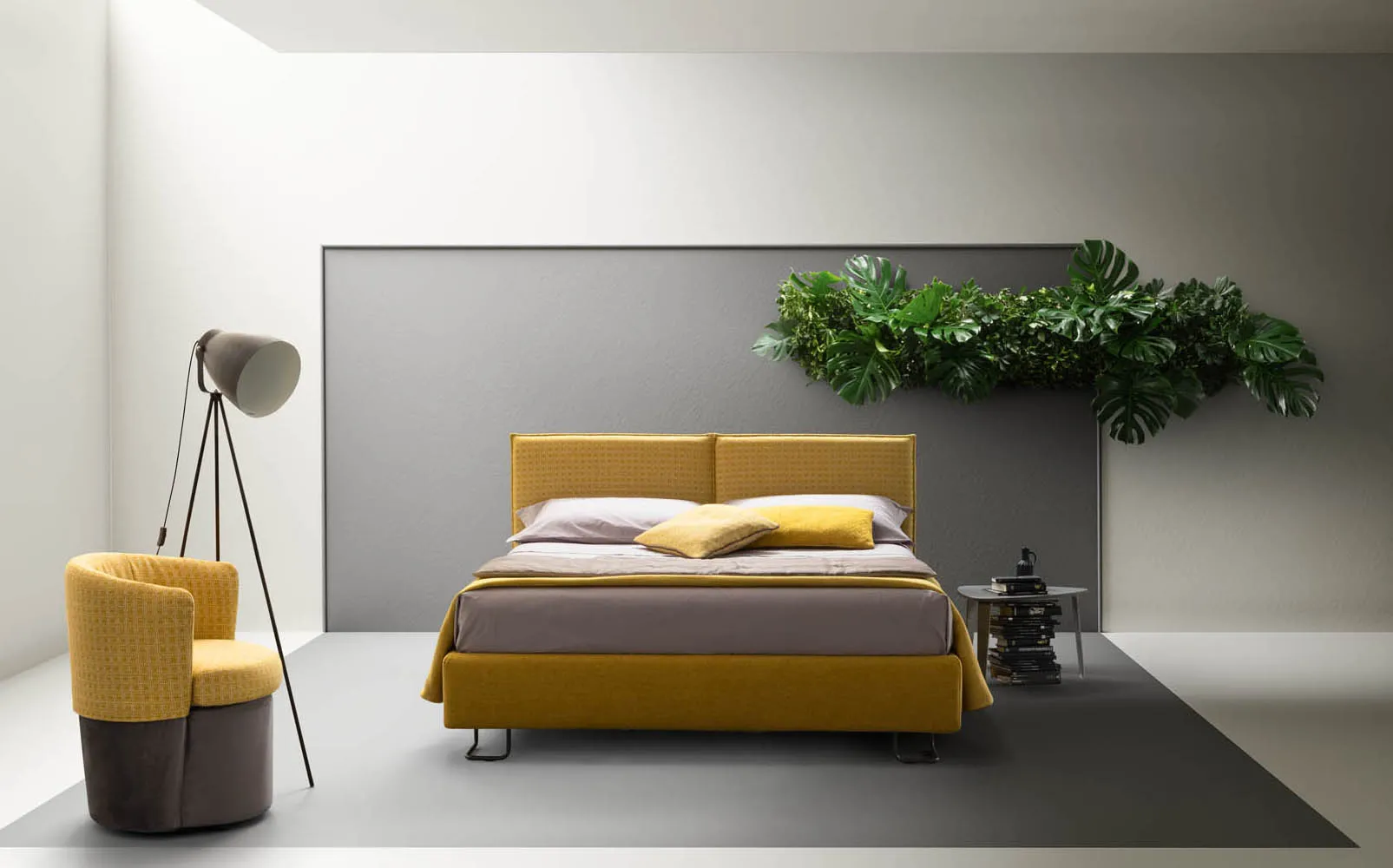 Letto matrimoniale Twist Samoa giallo senape con testiera in due pannelli, accanto a una poltroncina