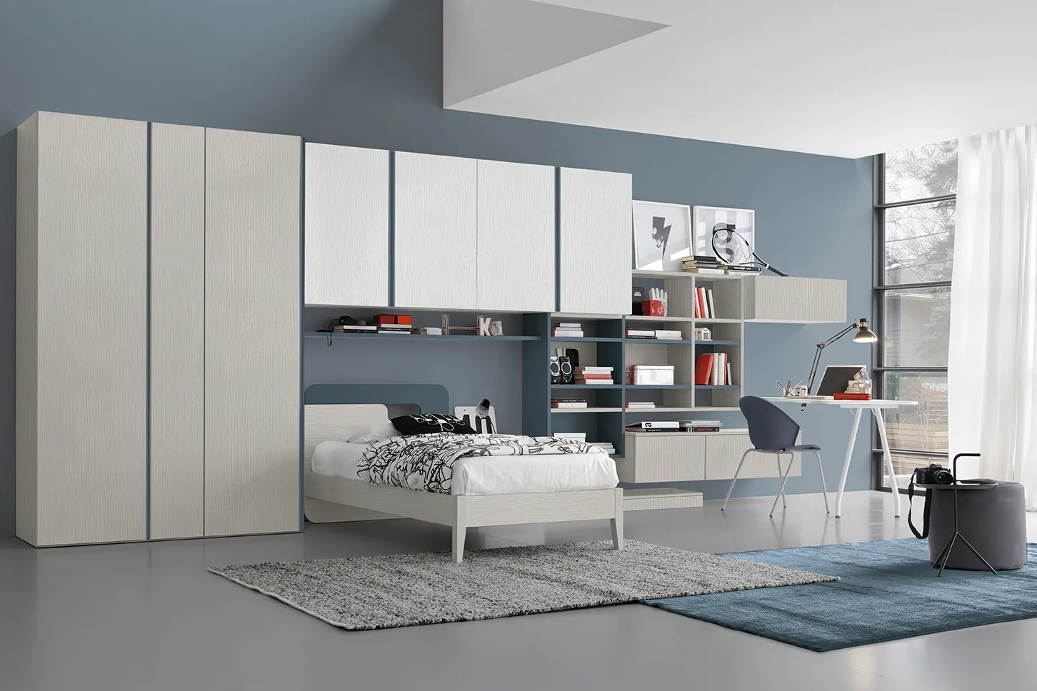 Letto singolo Hole Colombini bianco sotto un ponte di pensili e librerie