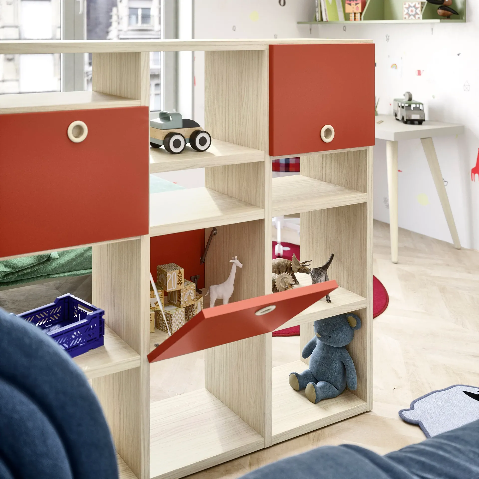 Vani della libreria Holly Nidi in legno chiaro con ante rosse e giochi