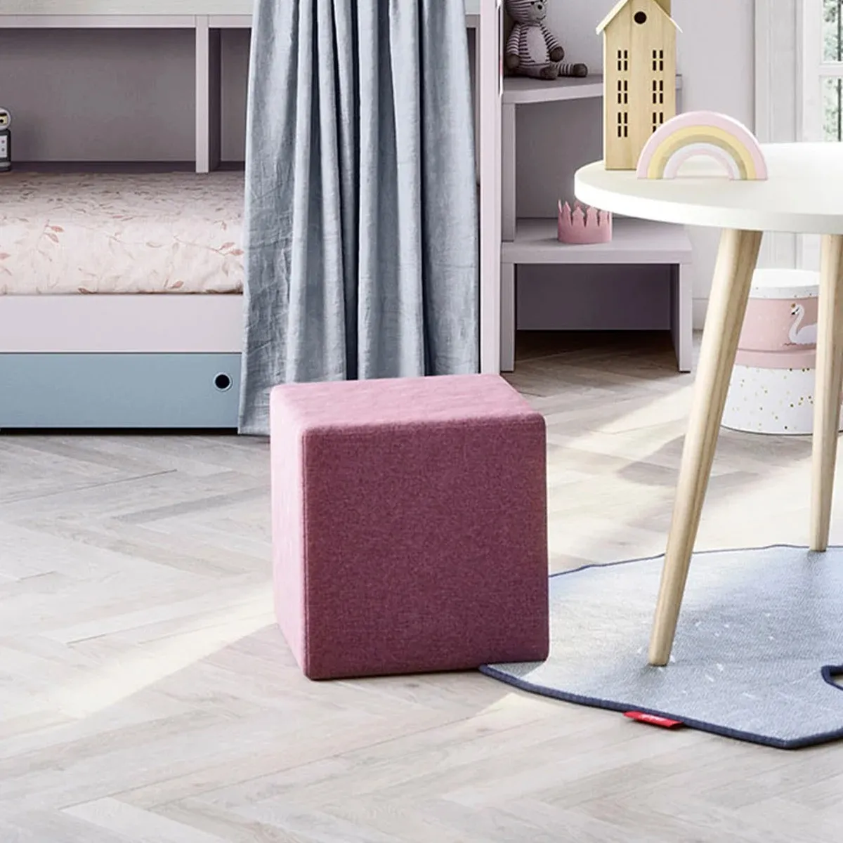 Pouf Cube Nidi rosa accanto al tavolino in cameretta