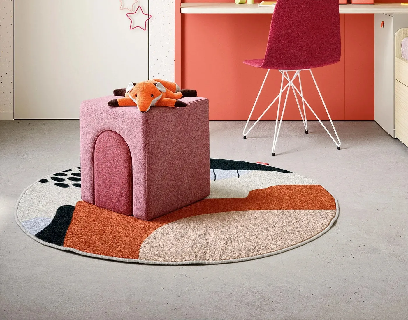 Pouf Iori Nidi rosa accanto alla scrivania corallo