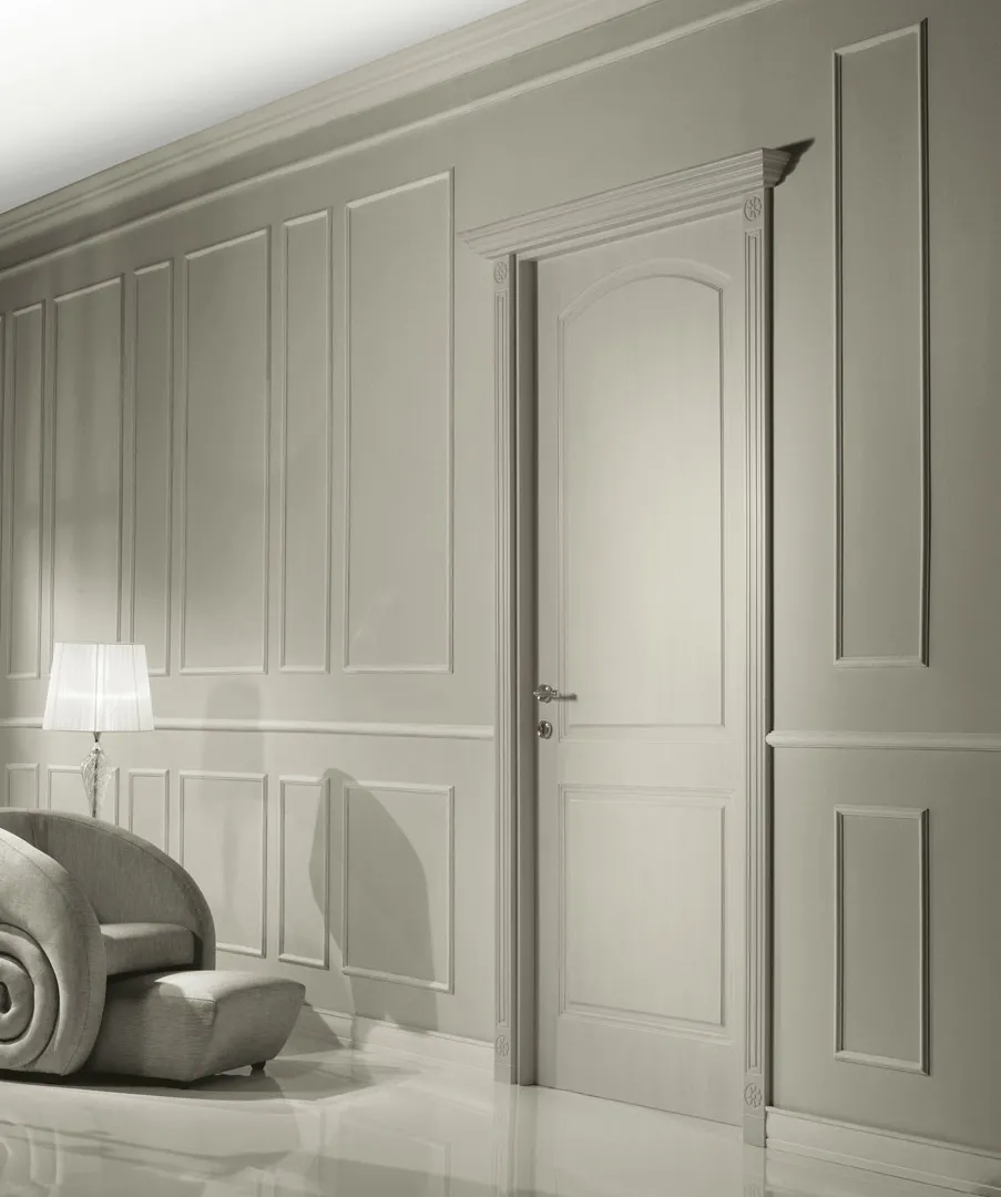 Porta interna Componibile Bernazzoli grigio chiaro fra pareti con boiserie a riquadri