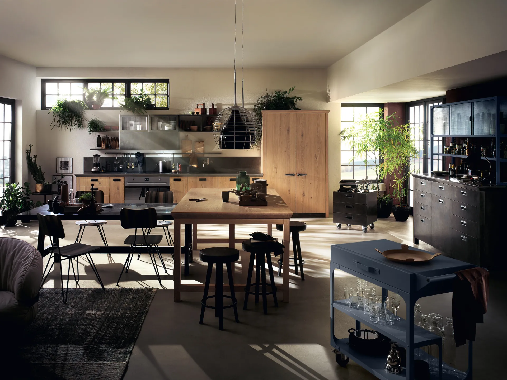 Cucina Diesel Social Kitchen Scavolini con isola e colonne in rovere nodato, tavolo alto e carrello blu