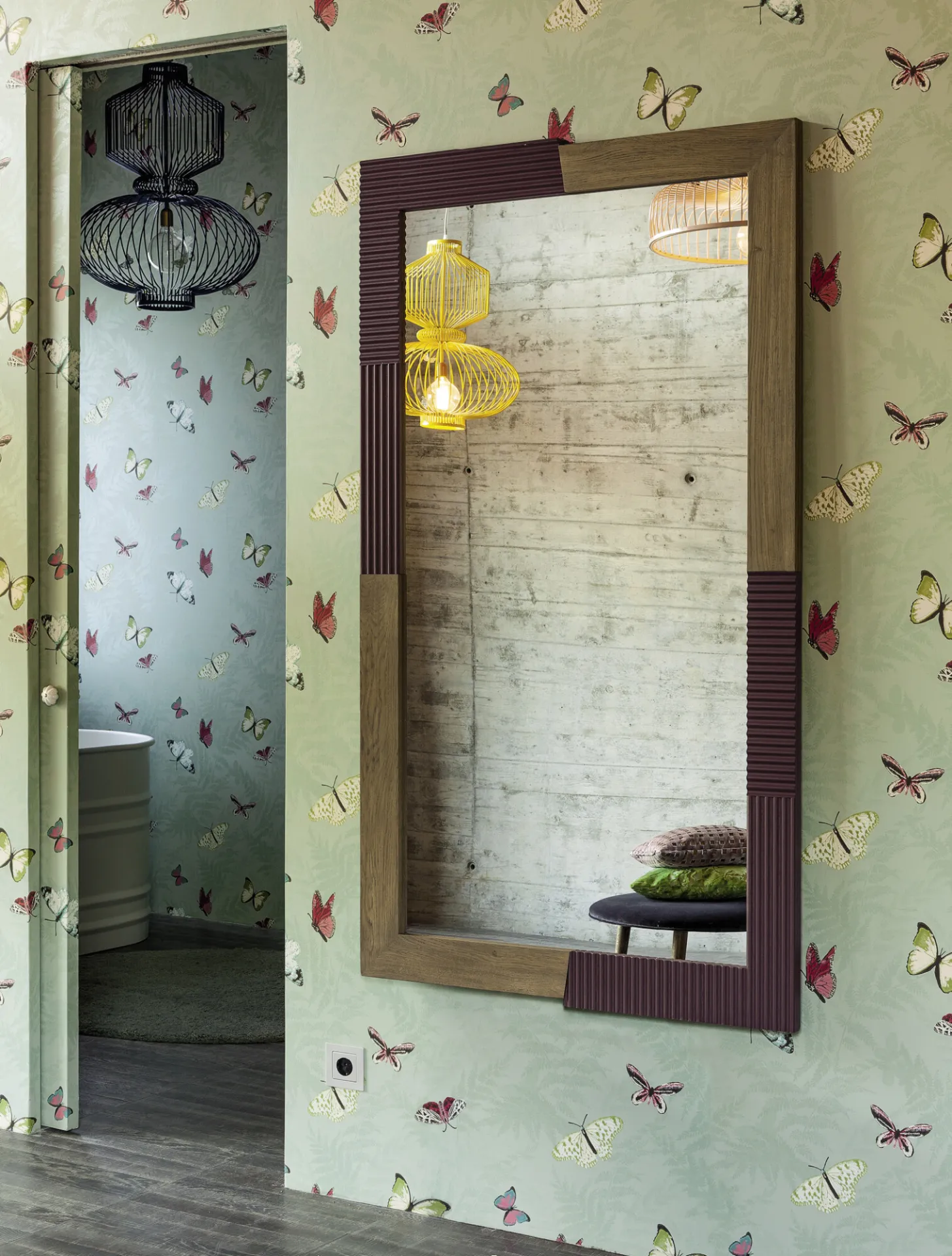 Specchio Zero.16 Devina Nais con cornice vinaccia e rovere su una parete con carta decorata