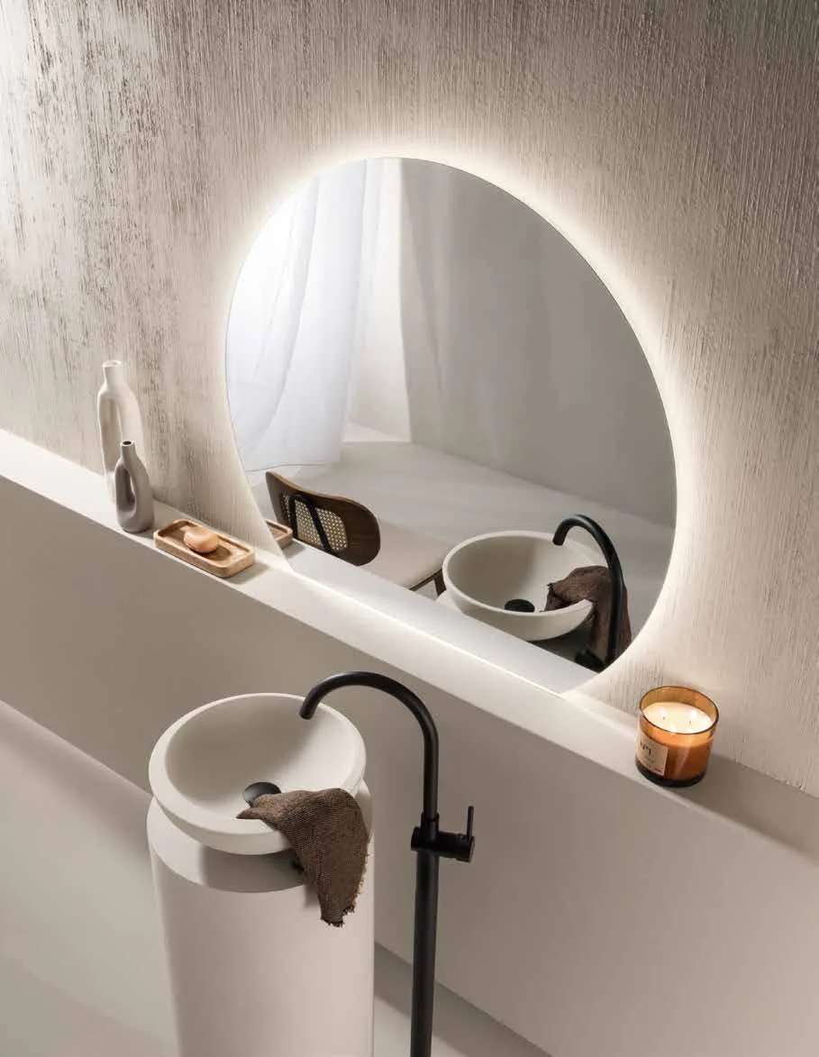 Specchio Alba Fan Europe sopra un lavabo con rubinetto nero