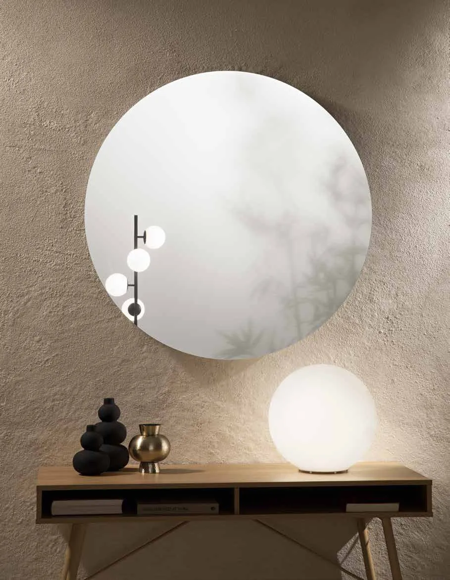 Specchio tondo Pure Fan Europe sopra una consolle con lampade a sfera