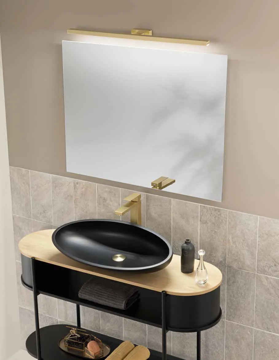 Specchio Pure Fan Europe sopra un lavabo nero su mobile dorato