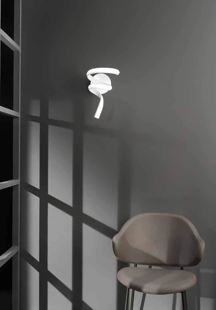 Applique Mystral Fan Europe su parete scura accanto a una poltrona