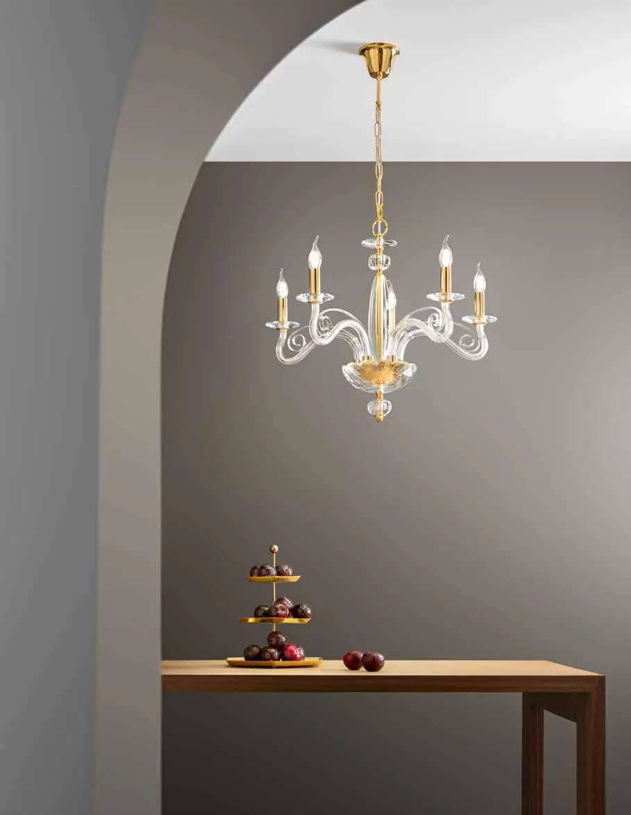 Lampadario Epoque Fan Europe in cristallo e oro sopra un tavolo