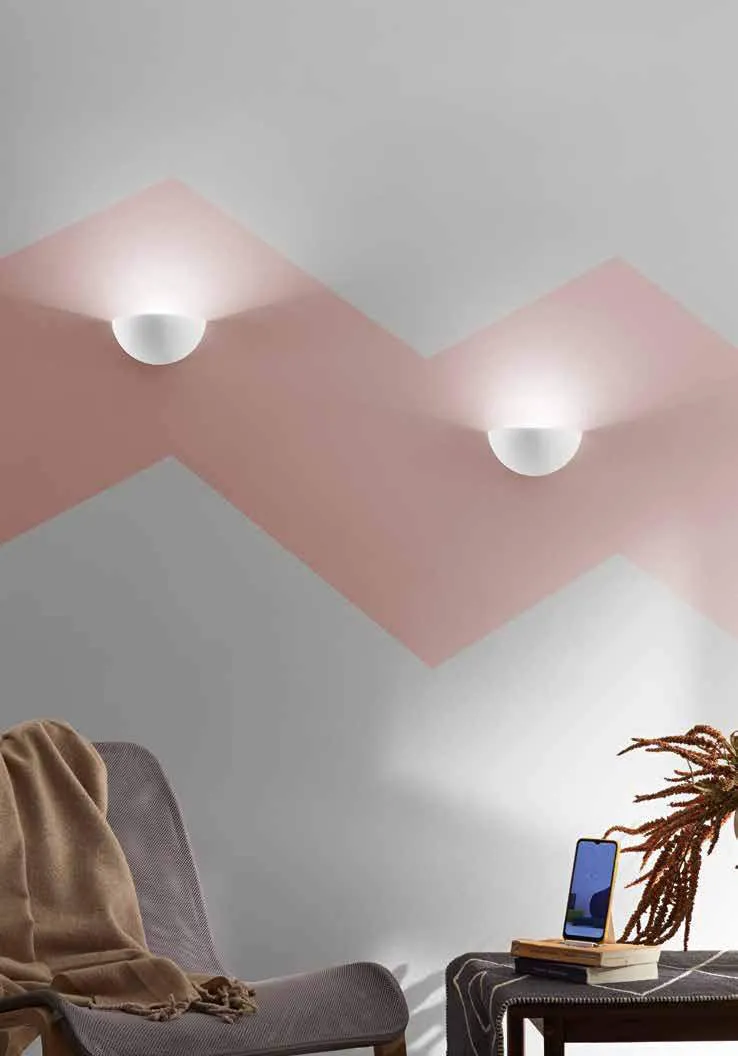 Due applique Piznair Fan Europe su parete dipinta rosa e grigia sopra un divano
