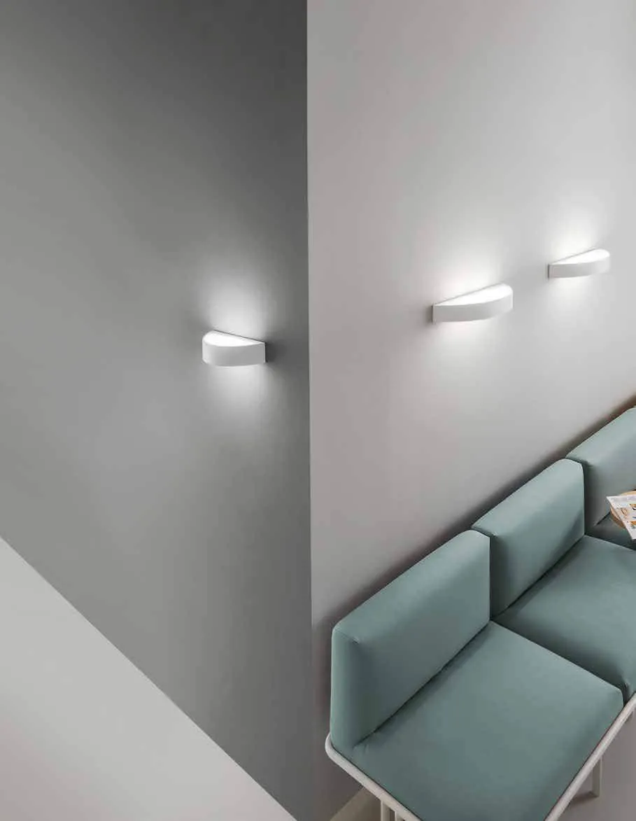 Applique Cortina Fan Europe in due misure sopra un divano azzurro