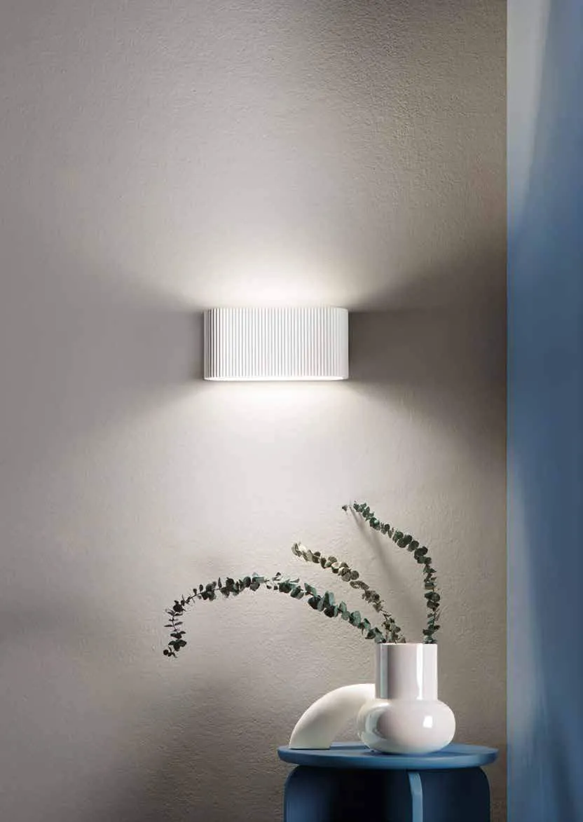 Applique Egeo Fan Europe in gesso su parete grigia accanto a una parete blu