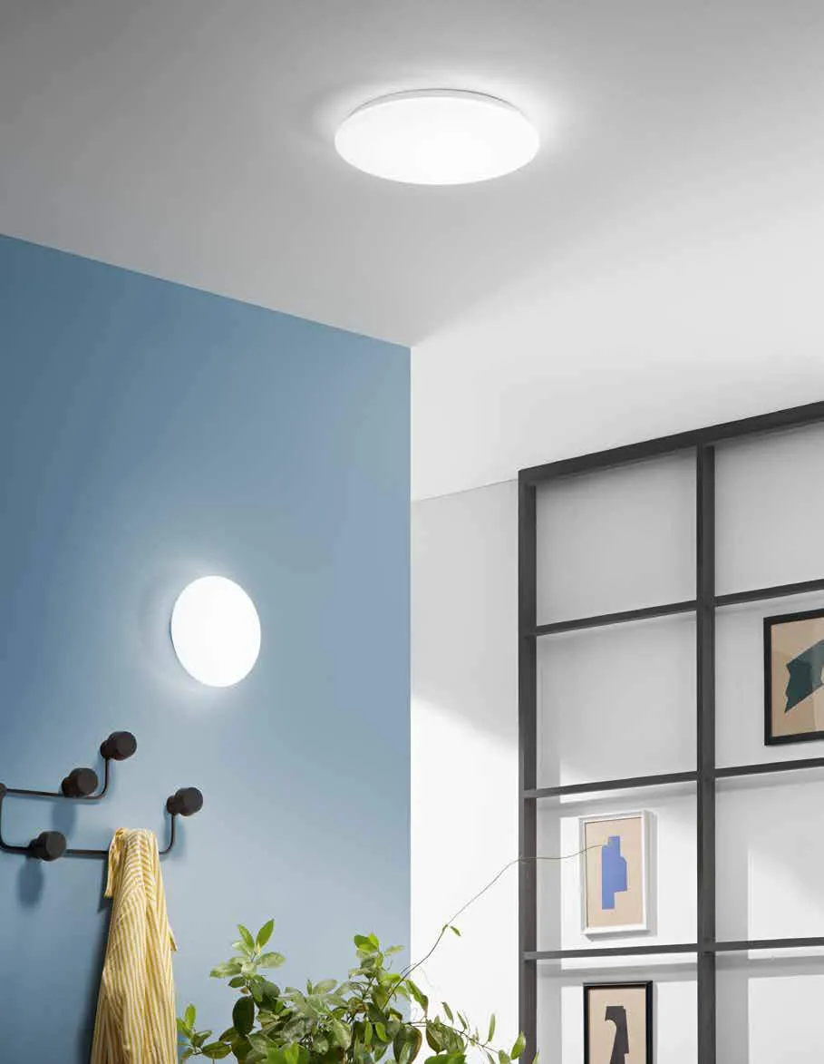 Plafoniere Sun Fan Europe tonde a soffitto e a parete accanto a una parete blu