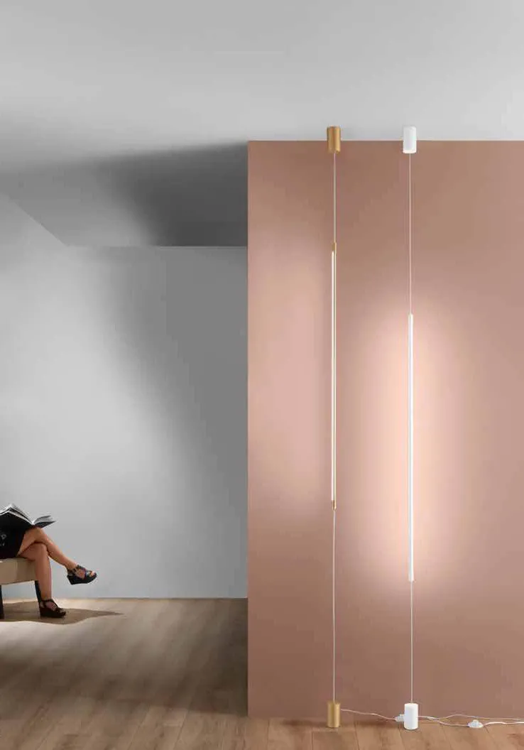 Lampada Gravity Fan Europe a barre luminose verticali davanti a un pannello rosa