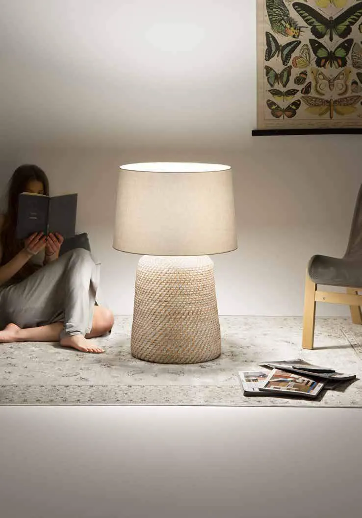 Lampada da tavolo Thonet Fan Europe in rattan accanto a una persona che legge a terra