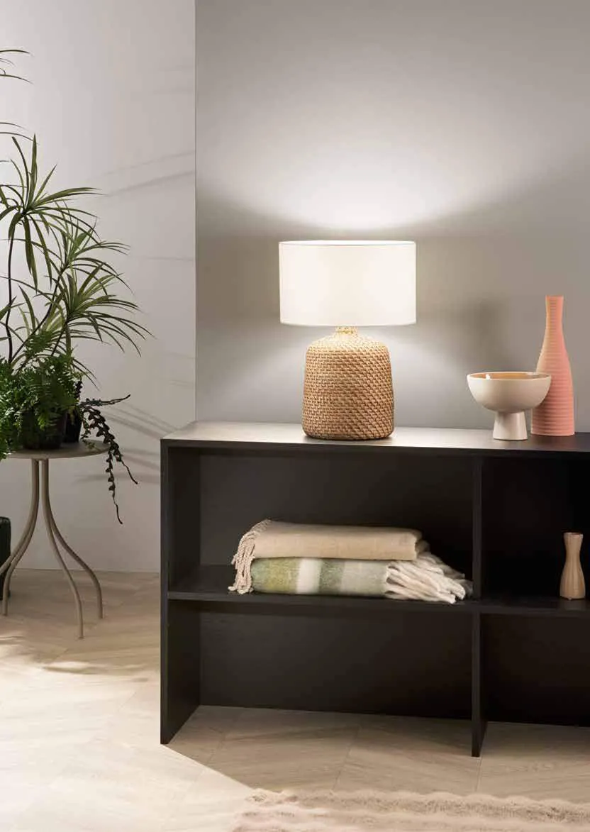 Lampada da tavolo Malacca Fan Europe con base intrecciata su un mobile nero
