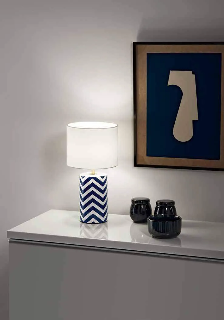 Lampada da tavolo Zeno Fan Europe con base a righe blu e bianche su un mobile bianco