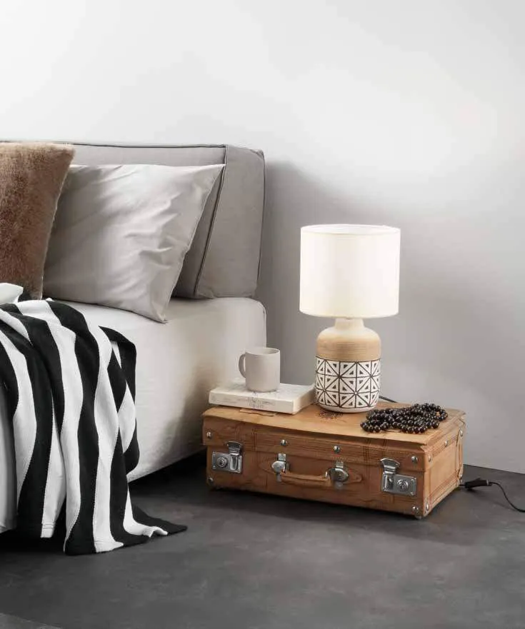 Lampada da tavolo Vietri Fan Europe su una valigia accanto al letto