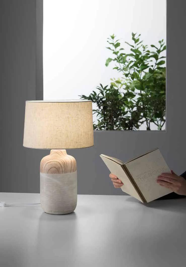 Lampada da tavolo Woody Fan Europe accanto a un libro aperto