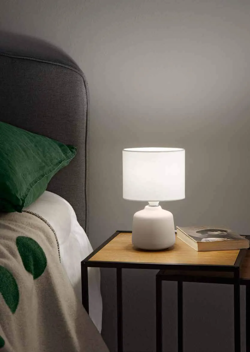 Lampada da tavolo Burano Fan Europe su un comodino accanto al letto