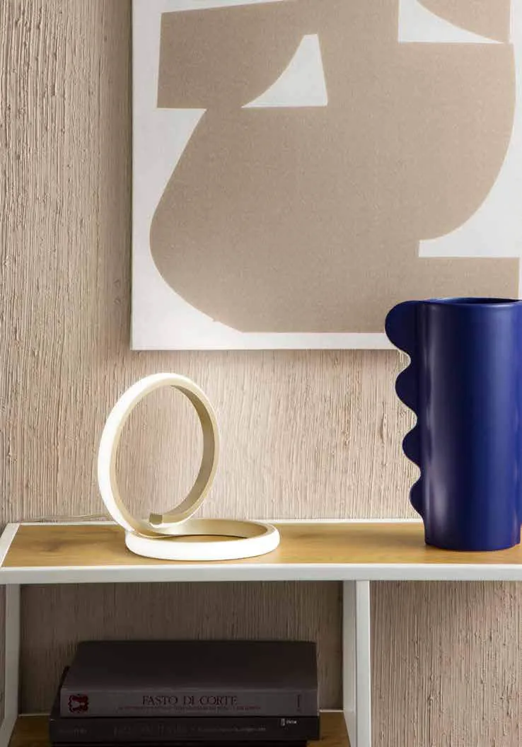 Lampada da tavolo Endless Fan Europe bianca su una mensola accanto a un vaso blu