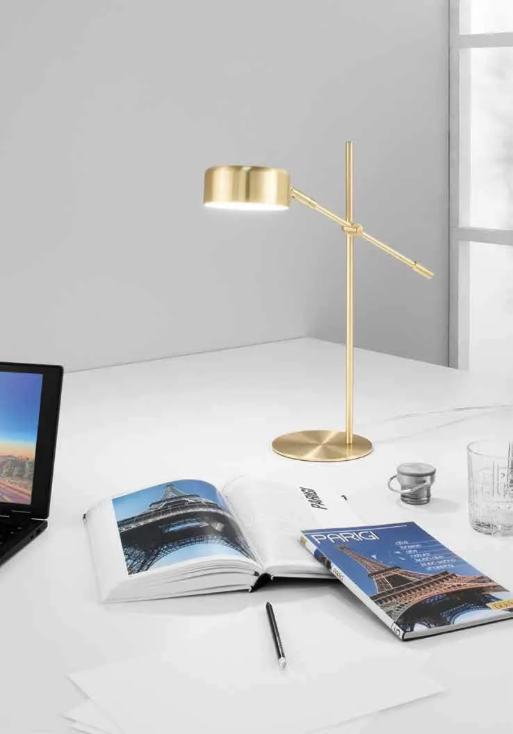 Lampada Eiffel Fan Europe oro su una scrivania con un libro aperto