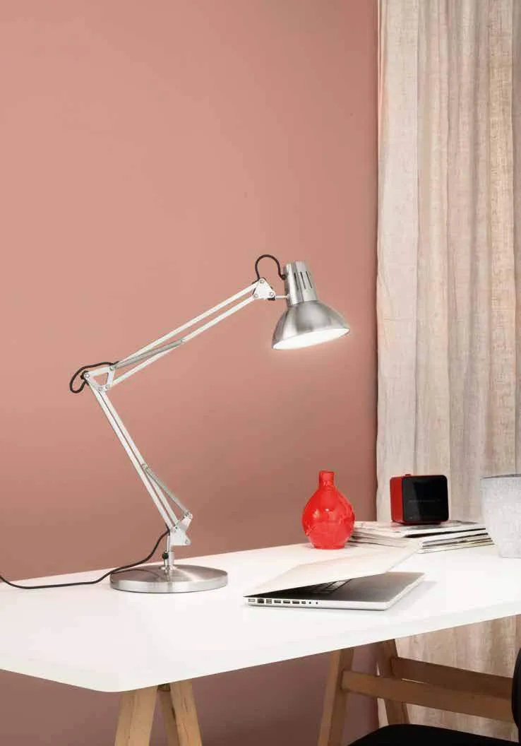 Lampada da scrivania Artifex Fan Europe nichel su una scrivania davanti a una parete rosa