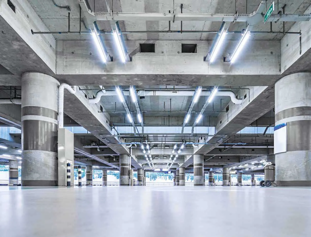 Sistema Busbar Fan Europe acceso in un parcheggio coperto con file di lampade lineari